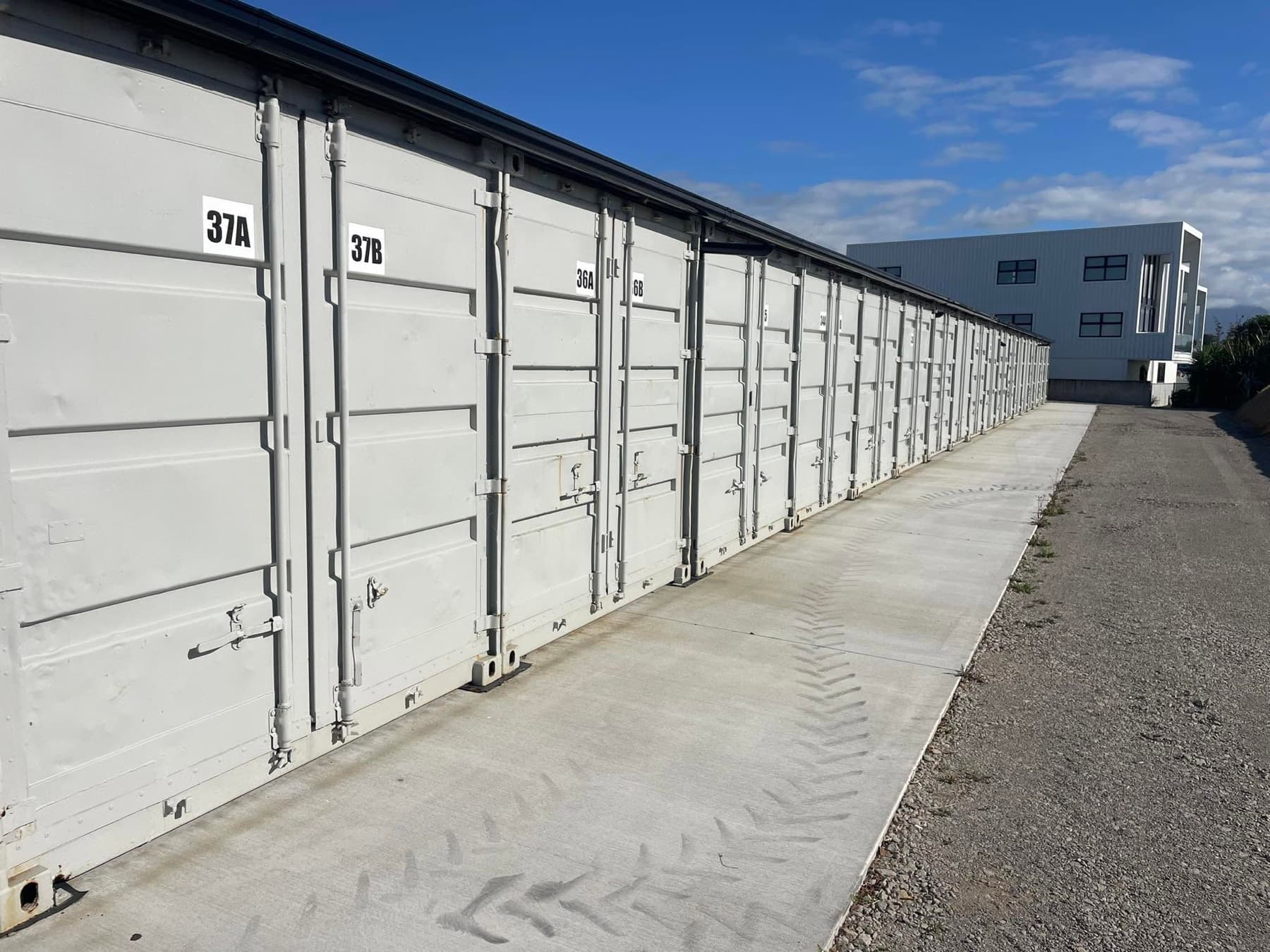 Numbered grey container doors on a concrete apron at Still Storage
