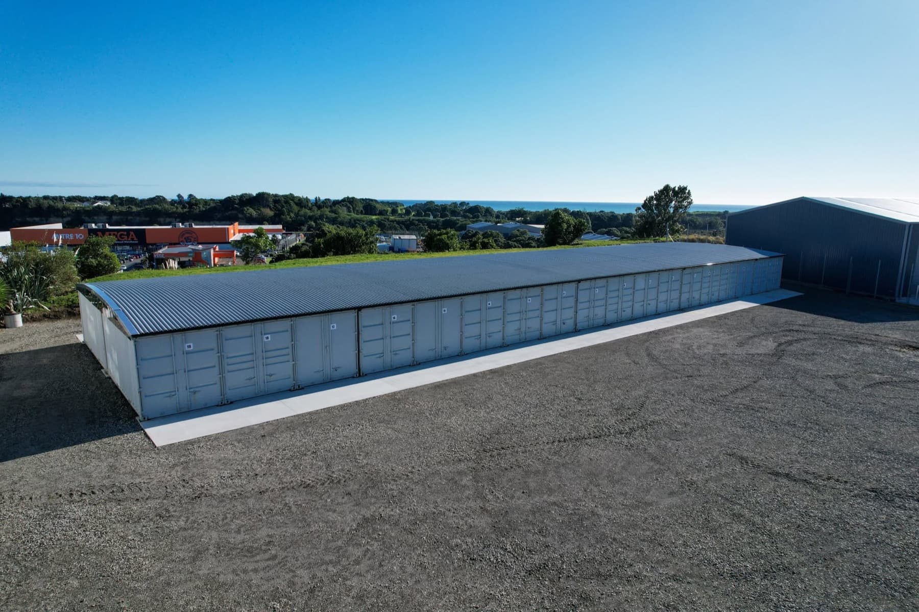 Wide yard in front of the roofed storage containers, with room for trucks and trailers